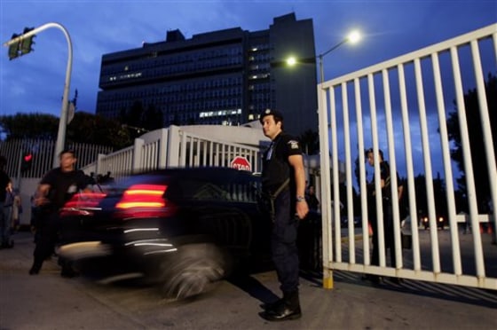 A car enters the Public Order Ministry building's compound just outside central Athens on Thursday.